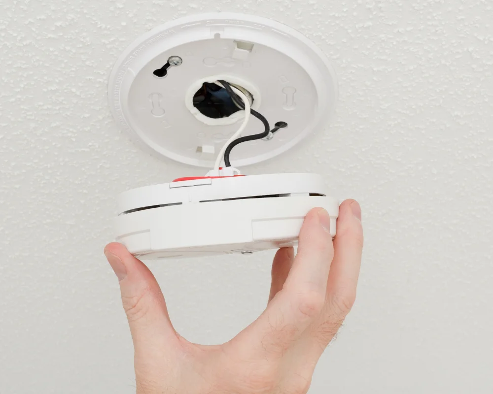 Technician removing an old smoke alarm